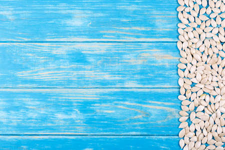 View of pumpkin seeds on a blue wooden background.の写真素材