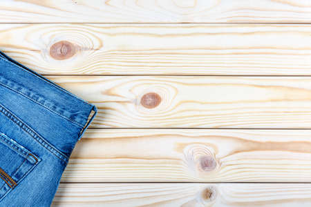 View of part of jeans lying on wooden background.の写真素材