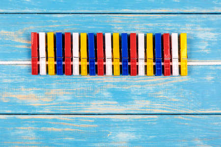 View of colored clothespins hanging on a ropeの写真素材