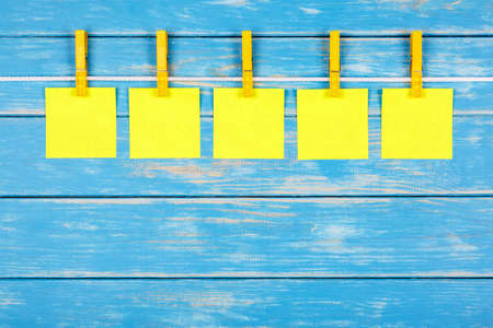 View of five clothespins hanging on a rope with five cardsの写真素材