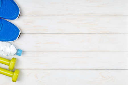 Bottle of water, dumbbells, sport shoes on white wood background. Concept plan.の写真素材
