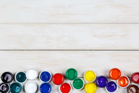 View of open cans of colored paint on the white wooden backgroundの写真素材