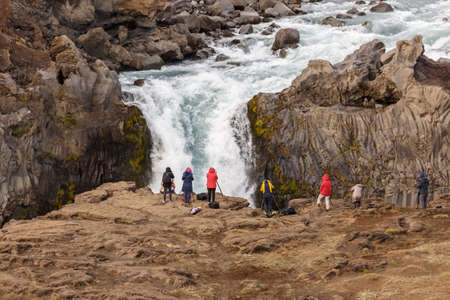Photographers taking photo of waterfall in Island. Focus on a photographer.の写真素材