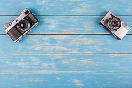Two old photocameras on a blue wooden backgroundの写真素材