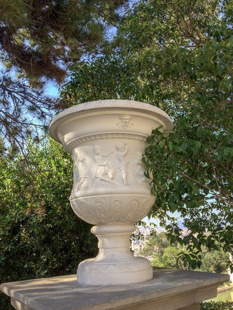 Sculpture on the pedestal, branches and leaves against the skyの写真素材