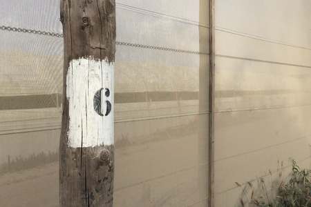 A black figure six on a white background, number on a pole, dense mesh as a background