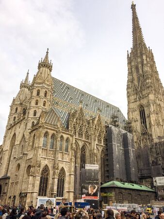 Austria, Vienna, 15/04/2017 people near the Catholic Cathedral, medieval Gothic Christian cathedral, restoration work, cloudy weather, many people on the street near the cathedralのeditorial素材