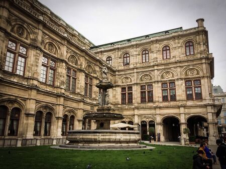 Austria, Vienna, 15/04/2017 opera house, fountain with sculptures, people near a beautiful building