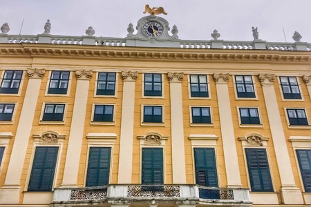 facade of the palace, many closed windows, clock on the roof of the house, yellow buildingのeditorial素材
