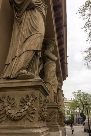 large statues on the streets of the city, statues of people holding a building on their heads,...