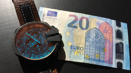 watch on top of money, time is money concept photoの写真素材