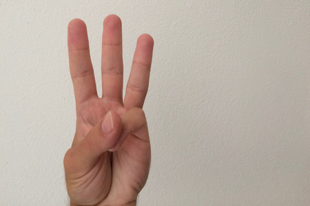 white man's palm, outstretched palm, hand on a white background, part of the body, part of the hand, white skin, three fingers, show the number, in the amount of three, hand gestureの写真素材