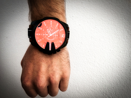 big watch on a white man's hand, make a fist, watch on the arm, part of the body, white skin, white background, hair on the arm, part of the hand, watch what time it isの写真素材