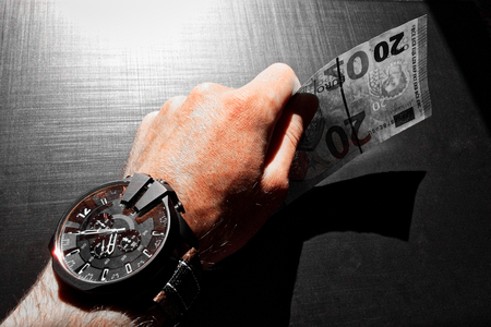 white man's hand holds a bank noteの写真素材