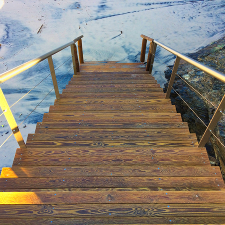 wooden staircase leading to the sandy beach, wood patterns, trash on the sandy beachの写真素材