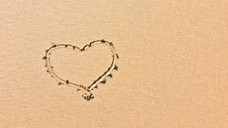 finger drawn heart on the sand, symbol of loveの写真素材