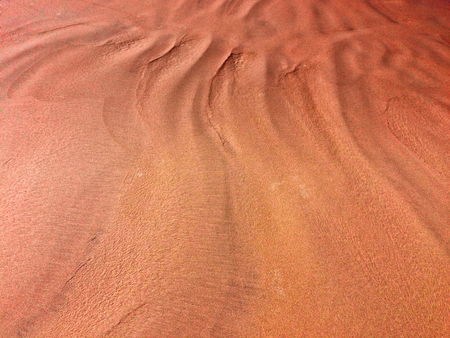 patterns from the waves and wind on the sand, sand of an unusual colorの写真素材