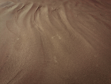 patterns from the waves and wind on the sand, sand of an unusual colorの写真素材