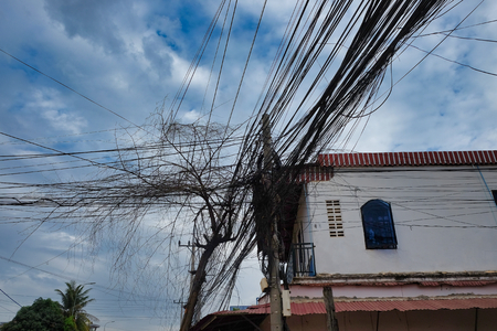 a huge number of electricity and telephone lines, the chaos of urban communicationsの写真素材