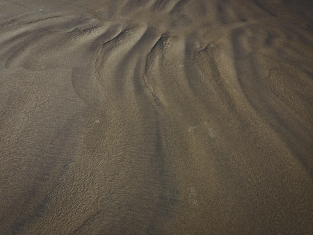 patterns from the waves and wind on the sand, sand of an unusual colorの写真素材