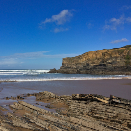 rocks on the ocean, seascape, beautiful sandy beach, clear blue sky, sunny weatherの写真素材