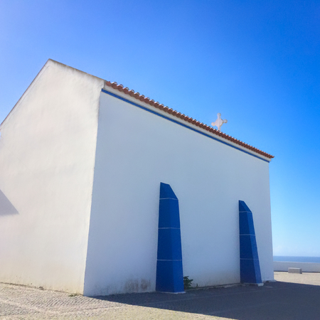 small white church in portugal on a sunny day, blue sky, combination of white and blue, place of prayer, religious buildingの写真素材