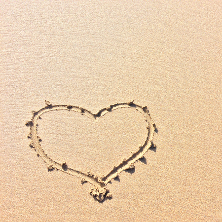finger drawn heart on the sand, symbol of loveの写真素材