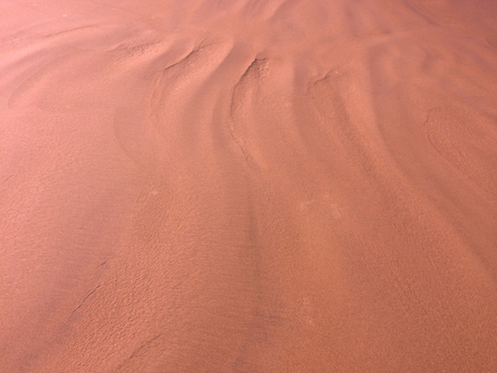 patterns from the waves and wind on the sand, sand of an unusual colorの写真素材