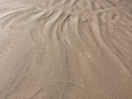patterns from the waves and wind on the sand, sand of an unusual colorの写真素材