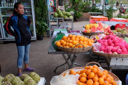 Cambodia, Siem Reap 12/08/2018 A young Asian girl sells fruit on a city streetのeditorial素材