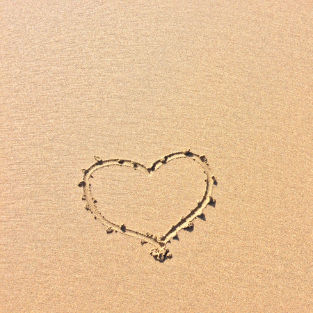 finger drawn heart on the sand, symbol of loveの写真素材
