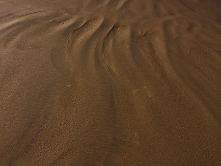 patterns from the waves and wind on the sand, sand of an unusual colorの写真素材