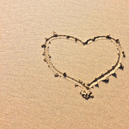 finger drawn heart on the sand, symbol of loveの写真素材