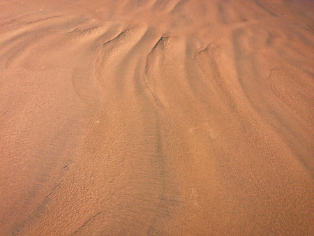 patterns from the waves and wind on the sand, sand of an unusual colorの写真素材