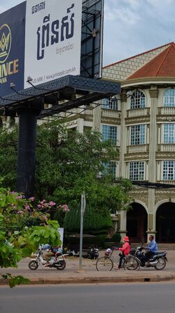 Cambodia, Siem Reap, 08/12/2018 scooters and cyclist drive past the hotel, Southeast Asiaのeditorial素材