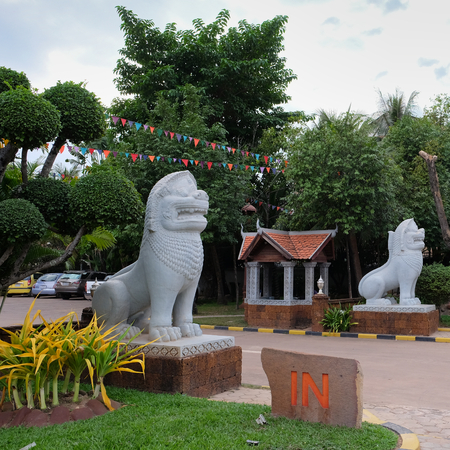 sculpture of a lion in front of the entrance to the city park, decorative treesの写真素材