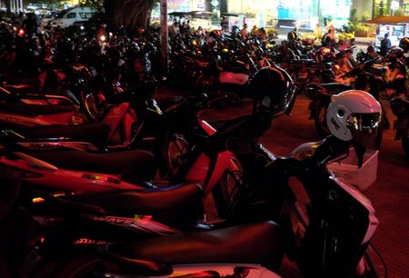 Siem Reap, Cambodia, December 11/2018 parking scooters, motorcycle helmet hanging on the steering wheel moped, beautiful night lightingのeditorial素材