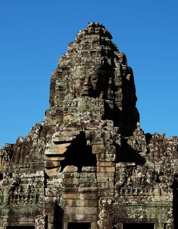 A huge human face built of stone blocks. Huge human faces on the towers of the Bayon temple in Cambodia. Architectural art of ancient civilizations.の写真素材