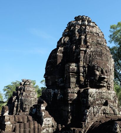 A huge human face built of stone blocks. Huge human faces on the towers of the Bayon temple in Cambodia. Architectural art of ancient civilizations.の写真素材