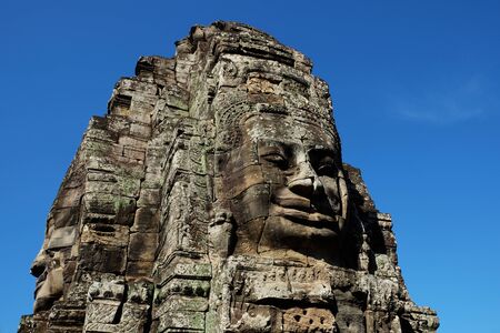 Fragment of the ancient stone temple Bayon in Cambodia. Stone face. The face of a man, folded with stone blocks.の写真素材