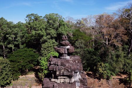 Ancient stone tower in the forest. The object of architectural art of medieval Southeast Asia. Stone carving, executed in Asian style.の写真素材