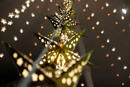 Decorative star-shaped lanterns suspended from the ceiling. Christmas garland.