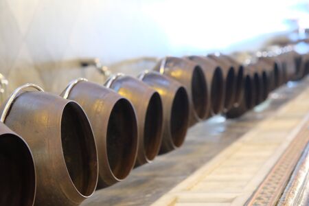 A row of pots stands in a Buddhist monastery. Selective focus.