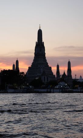 Thai temple Wat Arun stands on the banks of the Chao Phraya river at sunset. Evening landscape.の写真素材