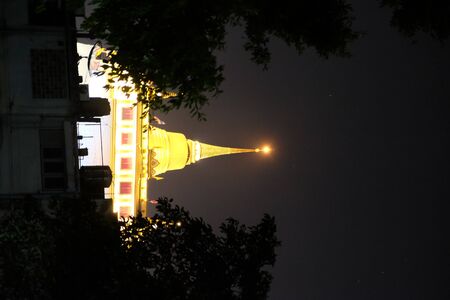 The spire of Wat Saket Temple is lit at night.の写真素材
