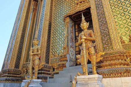 Two gilded sculptures of warriors guard the entrance to the magnificent Buddhist temple.