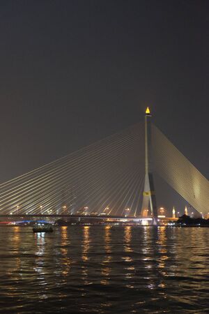 A huge bridge over the Chao Phraya River in Bangkok at night.