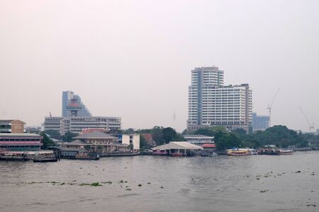 Bangkok, Thailand, December 28, 2018. Chao Phraya River Embankment. Modern buildings by the river in the capital of Thailand. City landscape.のeditorial素材