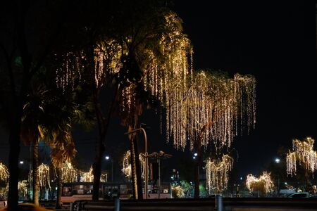 Bangkok, Thailand, December 26, 2018. Trees decorated with holiday lights grow along city roads at...