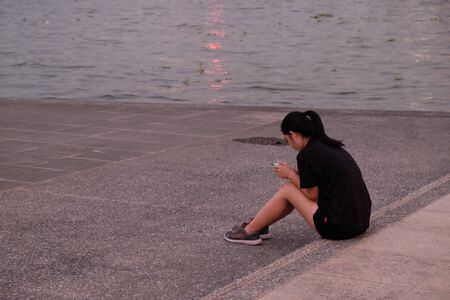 Bangkok, Thailand, December 28, 2018. A young Asian girl in sportswear is listening to music.のeditorial素材